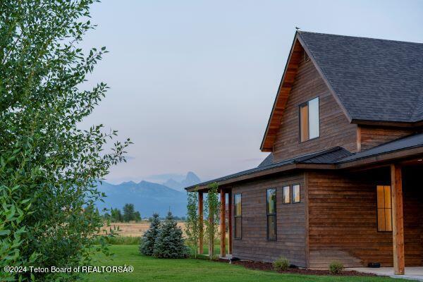 view of property exterior with a mountain view and a yard