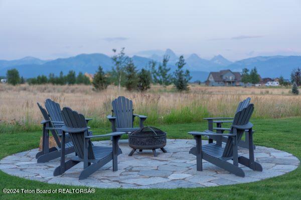 view of patio / terrace with a fire pit and a mountain view