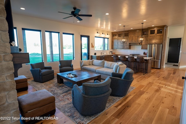 living room with ceiling fan and light hardwood / wood-style flooring