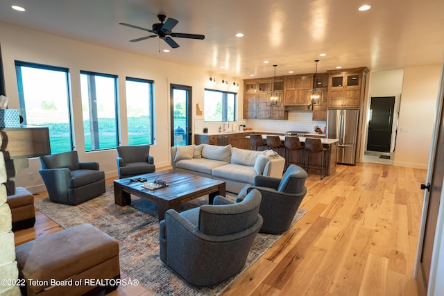 living room featuring light wood-type flooring and ceiling fan