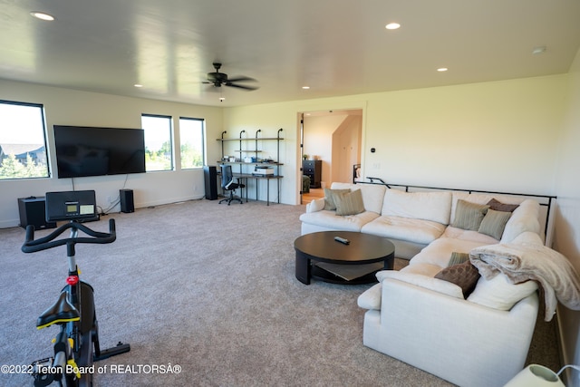 carpeted living room with ceiling fan