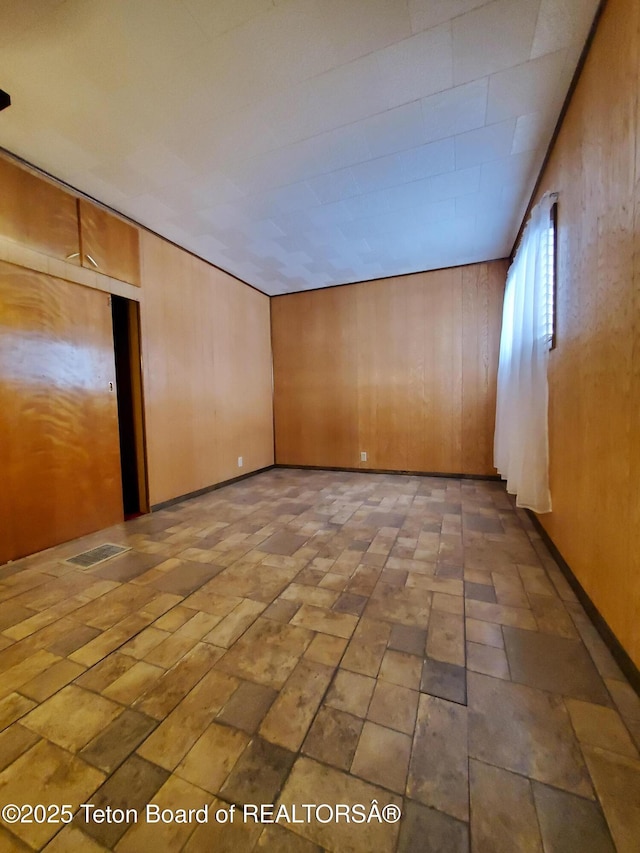 spare room featuring wooden walls