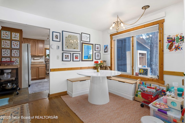 dining room featuring breakfast area, a notable chandelier, and light wood-type flooring