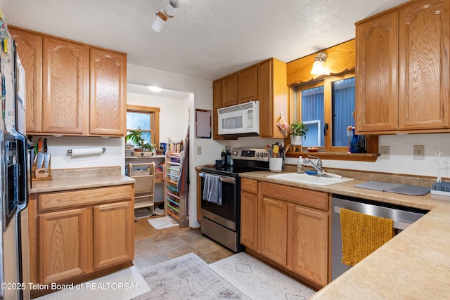 kitchen featuring sink, stainless steel appliances, and a textured ceiling