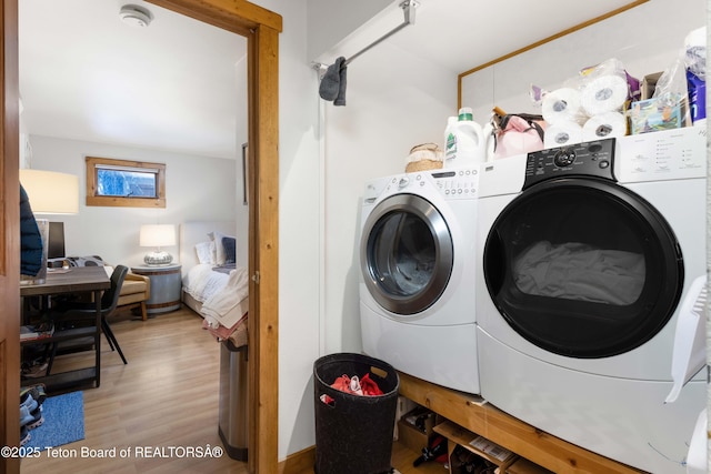 laundry area with independent washer and dryer and light wood-type flooring