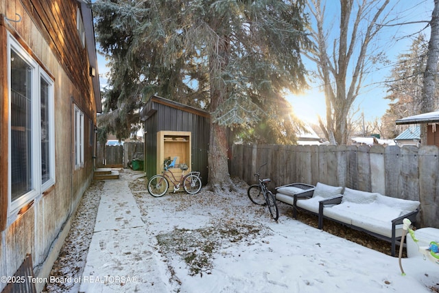 yard layered in snow with a shed