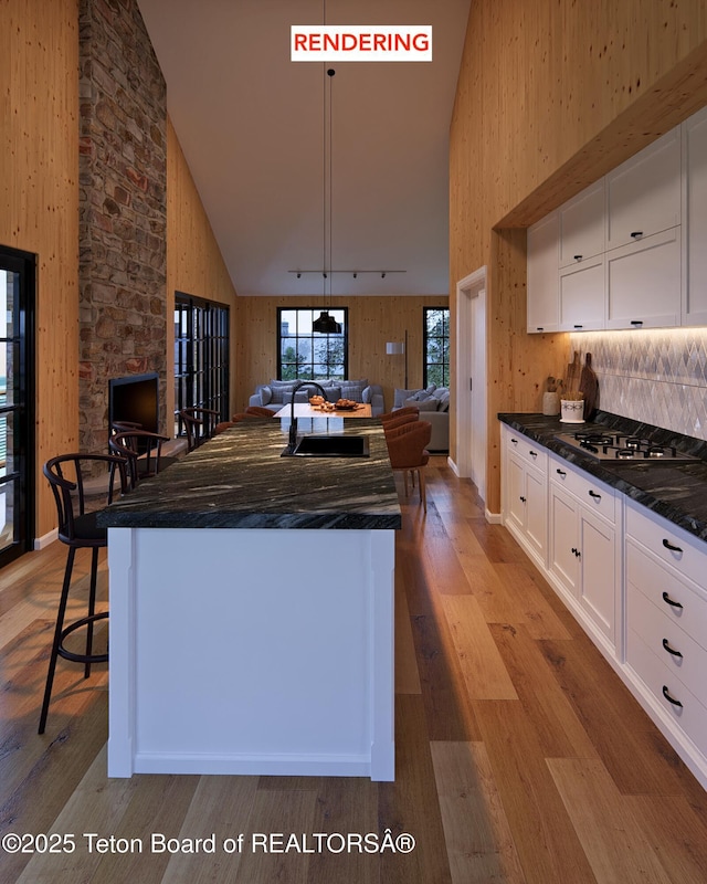 kitchen with high vaulted ceiling, track lighting, white cabinets, sink, and light wood-type flooring