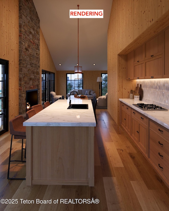 kitchen featuring gas cooktop, light brown cabinetry, high vaulted ceiling, and sink