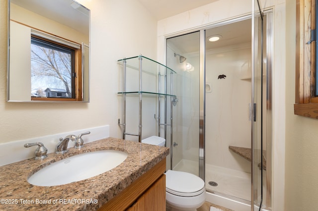 bathroom with vanity, toilet, and an enclosed shower