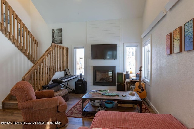 1875 W Cinnamon Teal Rd, Jackson, WY 83001 - living area featuring a fireplace, wood finished floors, stairway, a towering ceiling, and baseboards