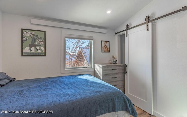 1875 W Cinnamon Teal Rd, Jackson, WY 83001 - bedroom featuring a barn door, wood finished floors, and recessed lighting