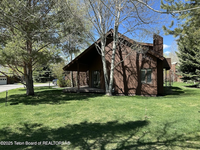 1875 W Cinnamon Teal Rd, Jackson, WY 83001 - view of property exterior with a chimney and a lawn