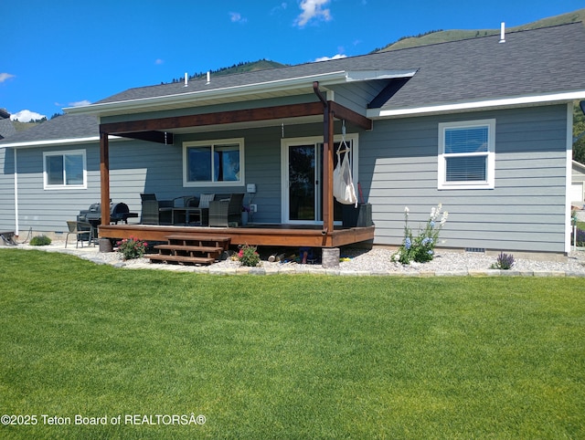 rear view of house featuring a deck and a yard