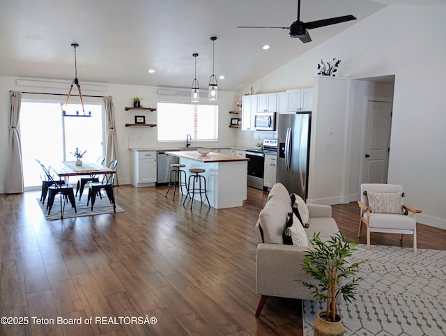 living room featuring ceiling fan, sink, high vaulted ceiling, and hardwood / wood-style flooring