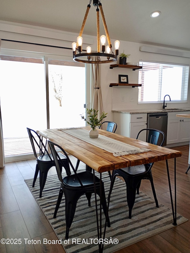 dining space with sink, light hardwood / wood-style flooring, and a chandelier