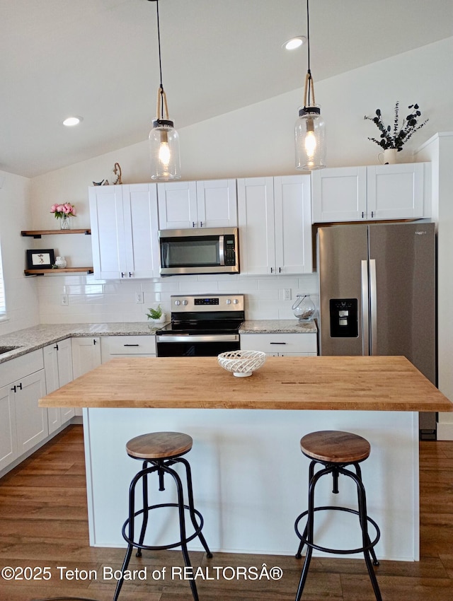 kitchen with white cabinets, wood counters, and appliances with stainless steel finishes