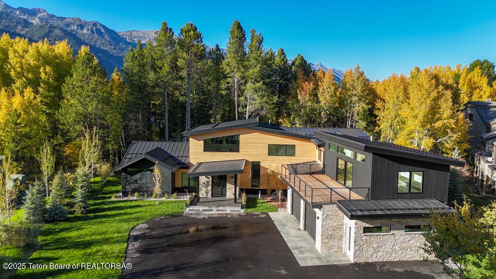 contemporary home with a mountain view, a garage, and a front lawn