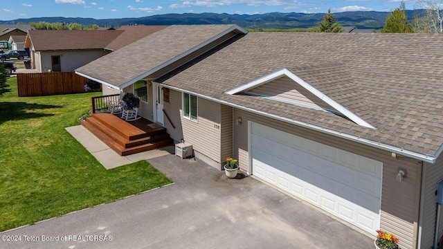 view of front facade with a mountain view, a garage, and a front lawn