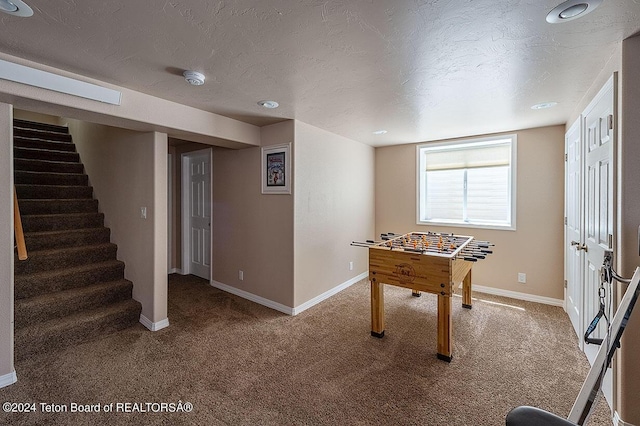 game room featuring carpet and a textured ceiling