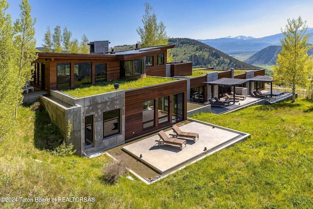 back of property featuring a patio area and a mountain view