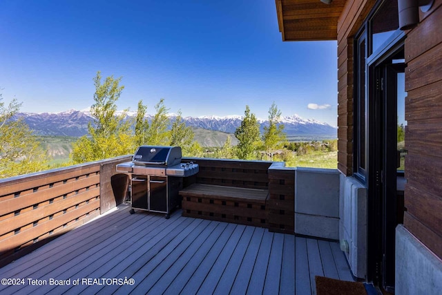 wooden deck with a mountain view and a grill