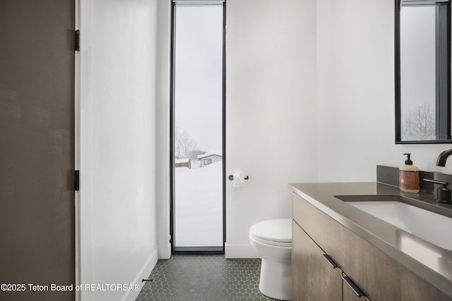 bathroom with toilet, vanity, and tile patterned floors