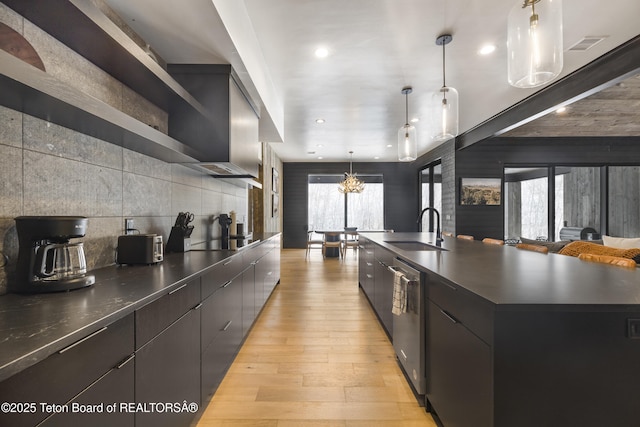 kitchen with sink, decorative light fixtures, light wood-type flooring, black electric cooktop, and a large island