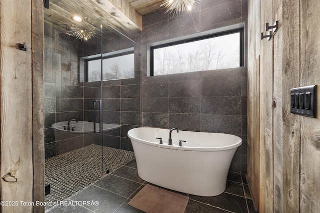 bathroom featuring plenty of natural light, tile walls, and shower with separate bathtub