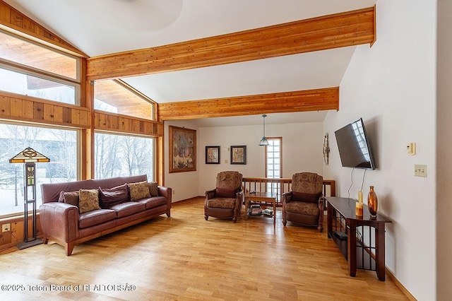 living room with vaulted ceiling with beams and light wood-type flooring