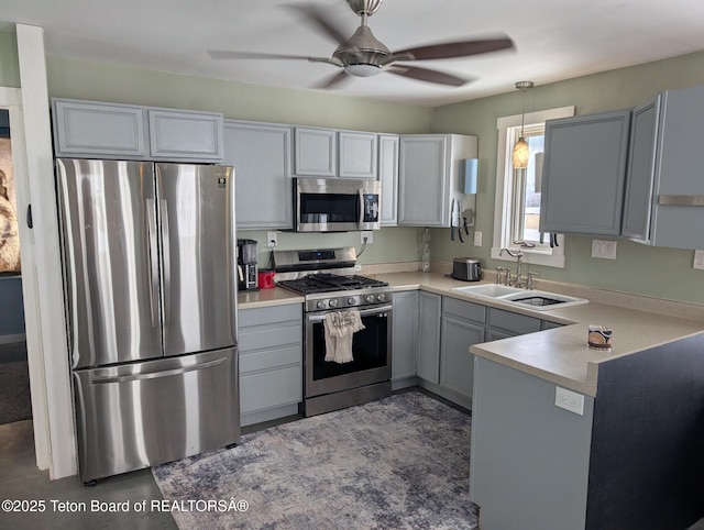 kitchen featuring decorative light fixtures, stainless steel appliances, sink, gray cabinets, and ceiling fan