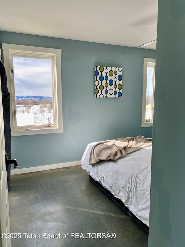 bedroom with baseboards and concrete flooring