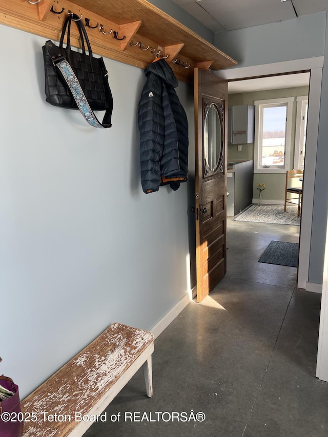 mudroom with finished concrete floors and baseboards