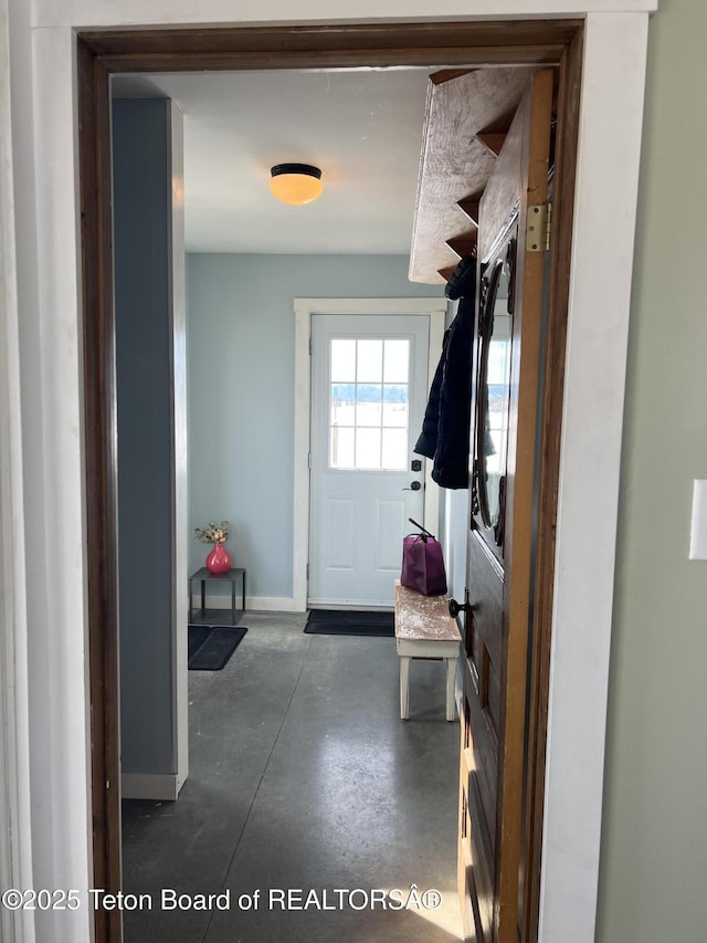 mudroom featuring baseboards and concrete flooring