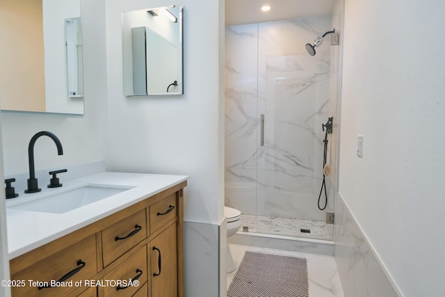 bathroom with an enclosed shower, vanity, and toilet