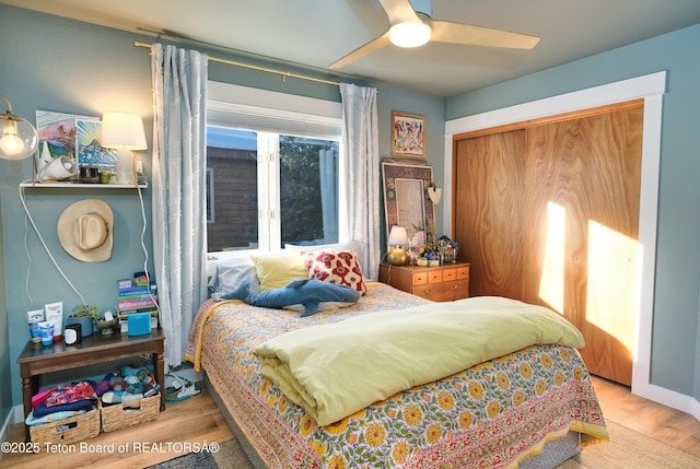 bedroom featuring ceiling fan, a closet, and light wood-type flooring