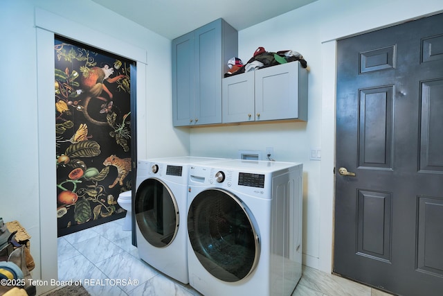 washroom featuring washer and clothes dryer and cabinets