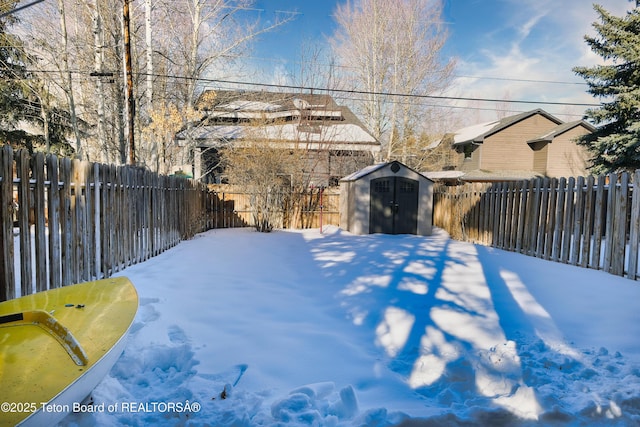 snowy yard featuring a shed