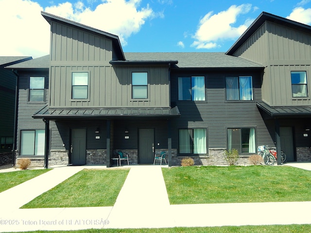 689 Baltoro Way, Driggs, ID 83422 - view of property with board and batten siding, a standing seam roof, a front lawn, and stone siding
