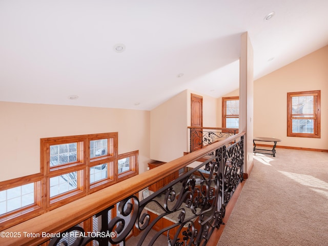 hall featuring carpet flooring and lofted ceiling