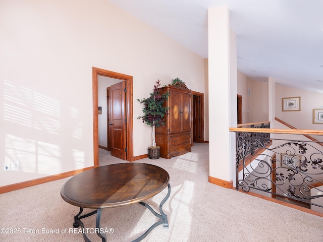 hall with light colored carpet and lofted ceiling