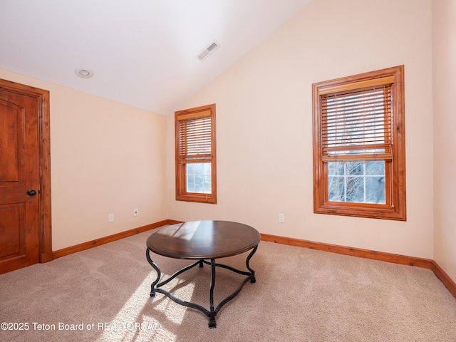 living area with lofted ceiling and light carpet