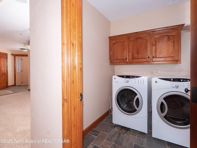 laundry room featuring cabinets, dark carpet, and washer and clothes dryer