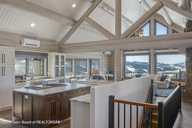 kitchen featuring a kitchen island, dark wood-type flooring, an AC wall unit, stainless steel gas stovetop, and a mountain view