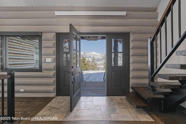 entryway with stone tile floors, wooden ceiling, stairway, beamed ceiling, and log walls