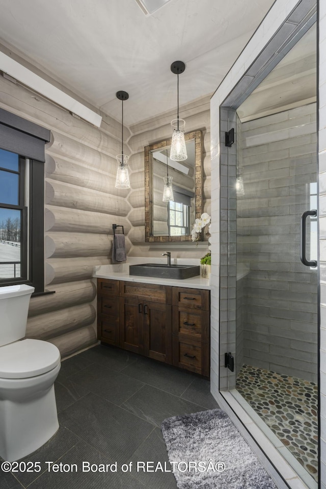 bathroom featuring toilet, a stall shower, tile patterned flooring, and vanity