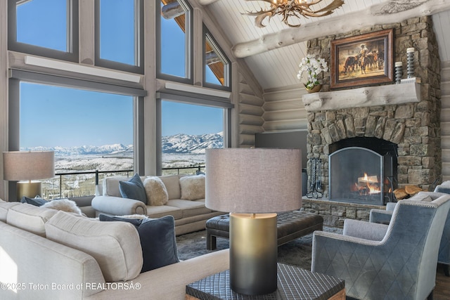 living room with plenty of natural light, a fireplace, a mountain view, and log walls