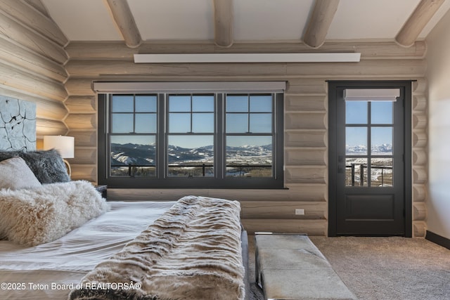 carpeted bedroom with beamed ceiling and log walls