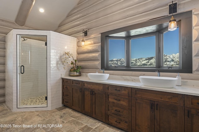 bathroom with vaulted ceiling, double vanity, a sink, and a shower stall