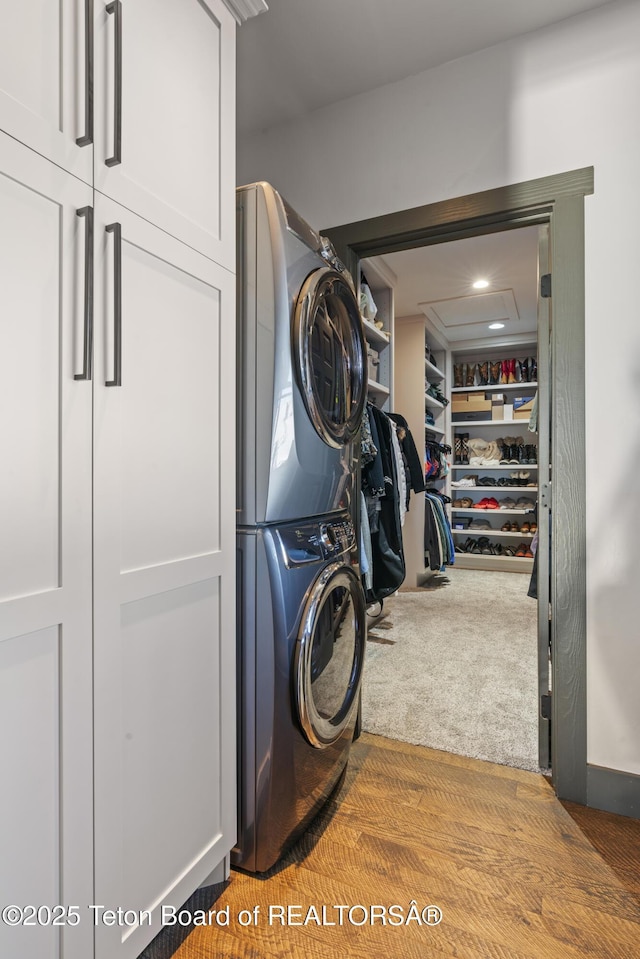 laundry room with stacked washer / drying machine and carpet flooring