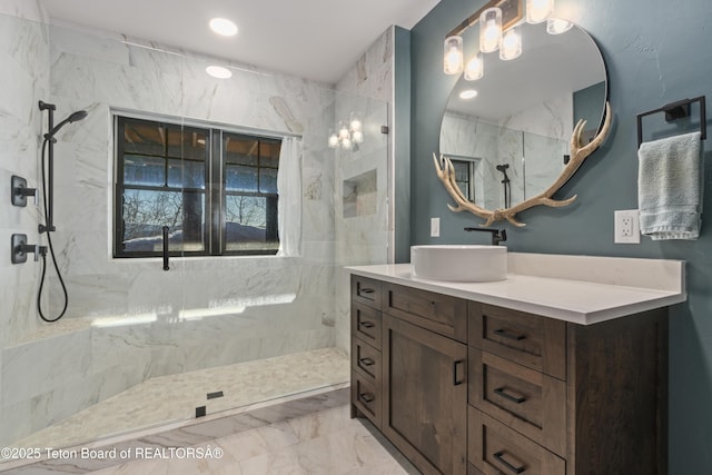 full bathroom featuring marble finish floor, a marble finish shower, and vanity